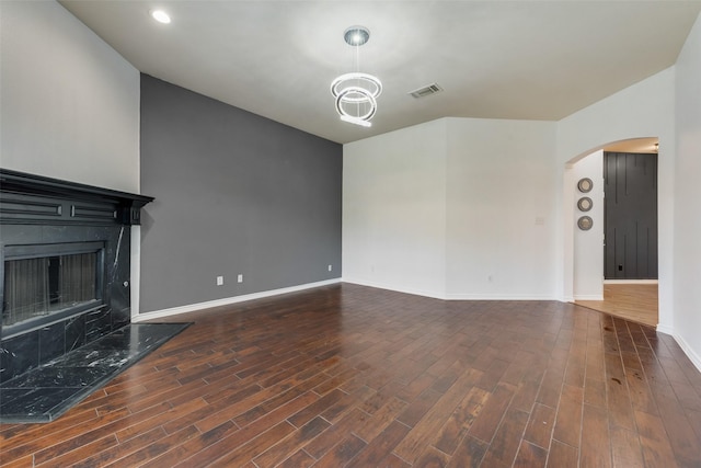 13293 Grayhawk Blvd, Frisco, TX 75033 - unfurnished living room with arched walkways, a fireplace, baseboards, and dark wood-type flooring