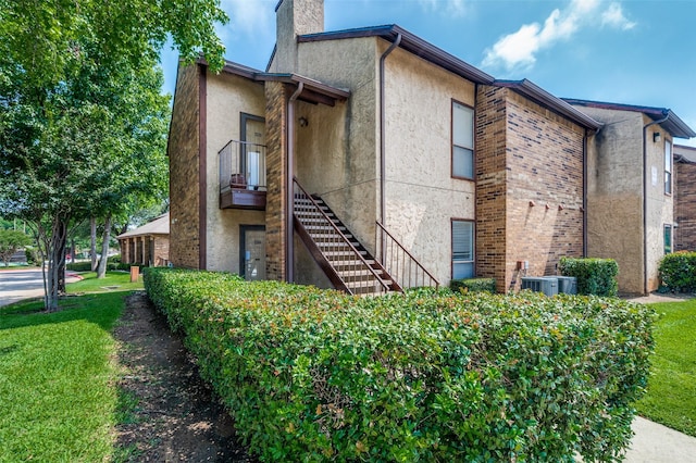 1301 Memory Ln Unit 4920, Arlington, TX 76011 - view of side of property featuring stucco siding, a chimney, stairway, and central air condition unit