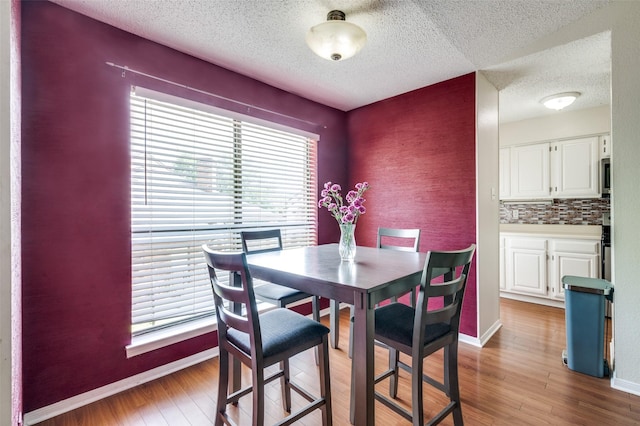 1301 Memory Ln Unit 4920, Arlington, TX 76011 - dining room with a textured ceiling, light wood-style flooring, and baseboards