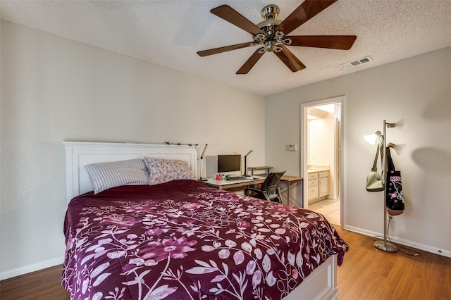 1301 Memory Ln Unit 4920, Arlington, TX 76011 - bedroom with baseboards, light wood-style flooring, ceiling fan, a textured ceiling, and connected bathroom