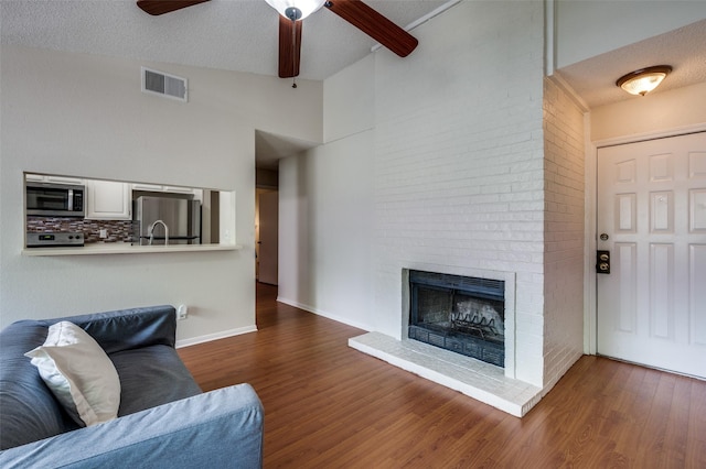 1301 Memory Ln Unit 4920, Arlington, TX 76011 - living area with ceiling fan, wood finished floors, a fireplace, high vaulted ceiling, and beam ceiling