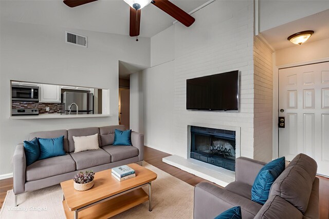 1301 Memory Ln Unit 4920, Arlington, TX 76011 - living room featuring wood finished floors, ceiling fan, and a fireplace