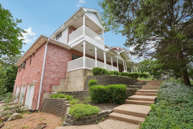 2224 Bluff Ct, Cedar Hill, TX 75104 - view of property exterior featuring a balcony, brick siding, an attached garage, and stairway