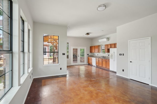 2224 Bluff Ct, Cedar Hill, TX 75104 - kitchen with white appliances, concrete floors, brown cabinets, baseboards, and an AC wall unit