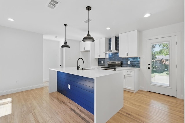 10626 Desdemona Dr, Dallas, TX 75228 - kitchen with stainless steel electric range, wall chimney range hood, a sink, light wood finished floors, and recessed lighting