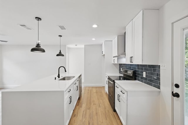 10626 Desdemona Dr, Dallas, TX 75228 - kitchen with stainless steel appliances, a sink, wall chimney exhaust hood, light countertops, and white cabinetry