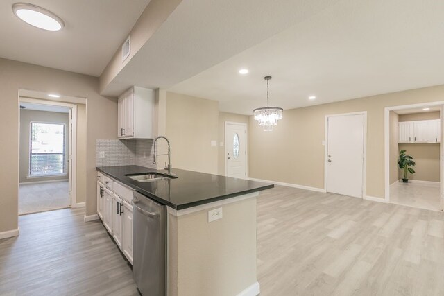 2400 Clearwood Dr, Arlington, TX 76014 - kitchen featuring a sink, stainless steel dishwasher, dark countertops, baseboards, and light wood-style floors