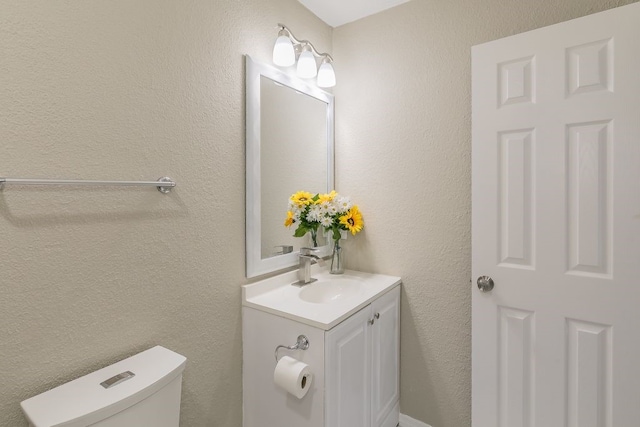 2400 Clearwood Dr, Arlington, TX 76014 - half bathroom with vanity, toilet, and a textured wall