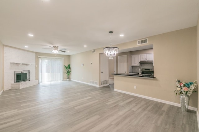 2400 Clearwood Dr, Arlington, TX 76014 - unfurnished living room with a ceiling fan, a chandelier, baseboards, light wood-style floors, and recessed lighting