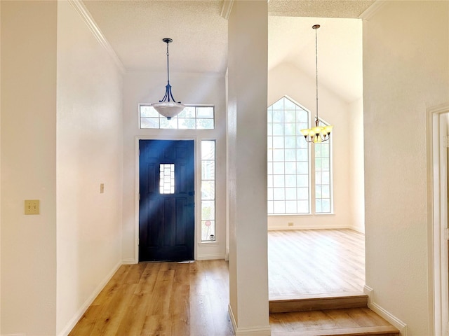 4209 Harvest Hill Ct, Carrollton, TX 75010 - entrance foyer featuring light wood-type flooring, a chandelier, baseboards, vaulted ceiling, and crown molding