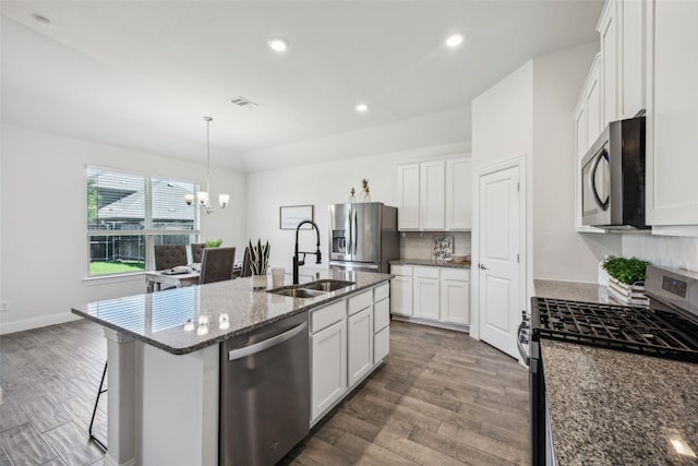 6217 Cheshire St, Celina, TX 76227 - kitchen with stainless steel appliances, a sink, a chandelier, wood finished floors, and recessed lighting