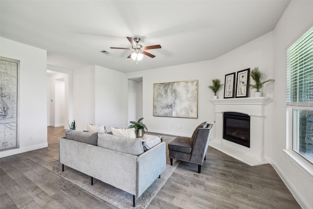 6217 Cheshire St, Celina, TX 76227 - living room featuring a glass covered fireplace, wood finished floors, a ceiling fan, and baseboards