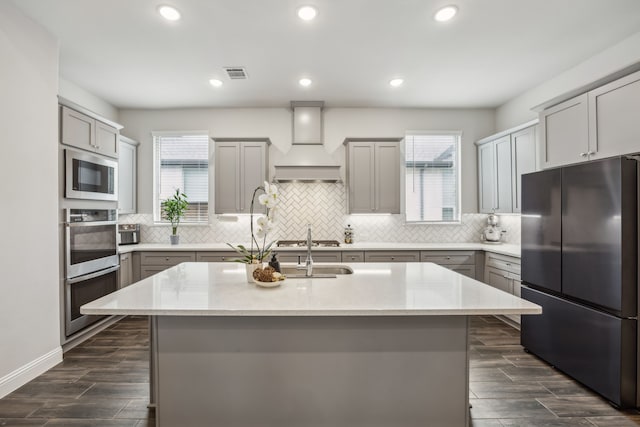 2811 Trinity Ridge St, Mansfield, TX 76063 - kitchen with stainless steel appliances, custom range hood, gray cabinetry, healthy amount of natural light, and recessed lighting