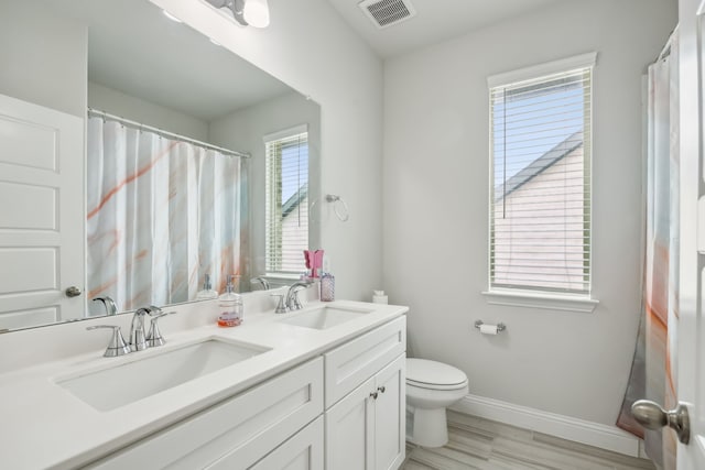 2811 Trinity Ridge St, Mansfield, TX 76063 - bathroom with double vanity, toilet, baseboards, and wood finished floors