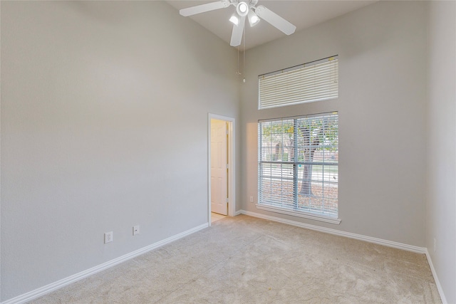 2728 Gull Lake Dr, Plano, TX 75025 - empty room with light colored carpet, baseboards, a ceiling fan, and a towering ceiling