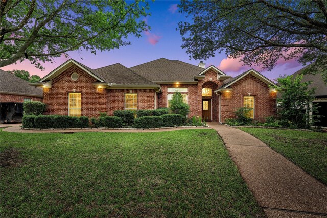 1405 Gunnison Dr, Waco, TX 76712 - view of front of house with a yard, brick siding, a chimney, and a shingled roof