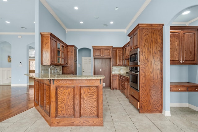 1405 Gunnison Dr, Waco, TX 76712 - kitchen featuring stainless steel appliances, arched walkways, a peninsula, crown molding, and light stone countertops