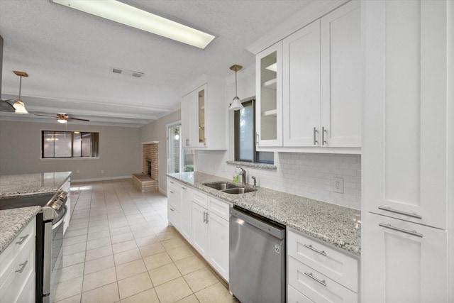 3416 Bristol Dr, Arlington, TX 76013 - kitchen with appliances with stainless steel finishes, a sink, white cabinetry, light tile patterned flooring, and a ceiling fan