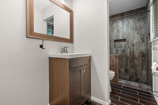 3416 Bristol Dr, Arlington, TX 76013 - bathroom with vanity, a shower stall, toilet, a textured wall, and wood tiled floors