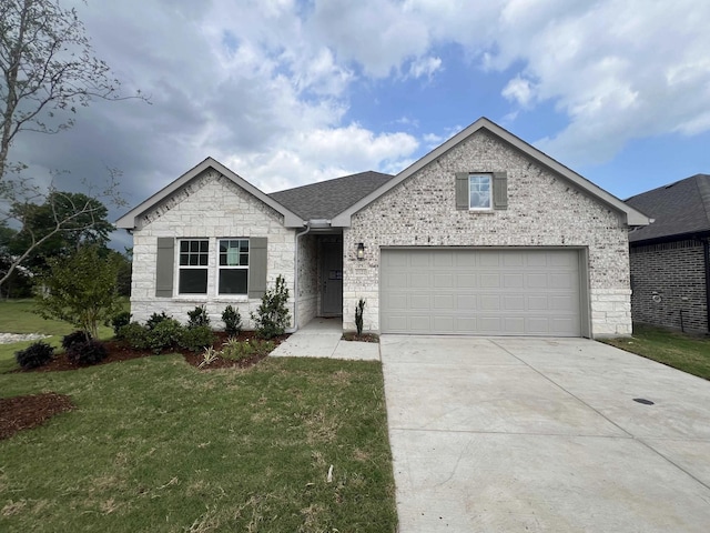 2121 Williams, Princeton, TX 75407 - view of front of property featuring concrete driveway, a front yard, stone siding, and a garage