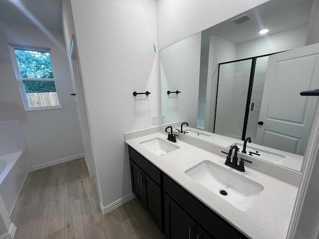 2121 Williams, Princeton, TX 75407 - bathroom with double vanity, wood finished floors, a bath, a shower stall, and baseboards