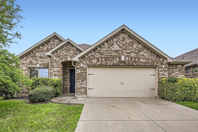 597 W Fate Main Pl, Fate, TX 75087 - view of front of house with an attached garage, driveway, and brick siding