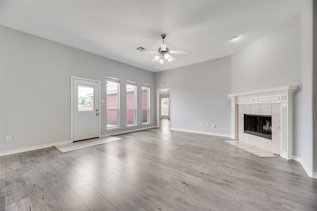 1707 Balboa Ln, Allen, TX 75002 - unfurnished living room featuring a ceiling fan, light wood-style floors, baseboards, and a tile fireplace