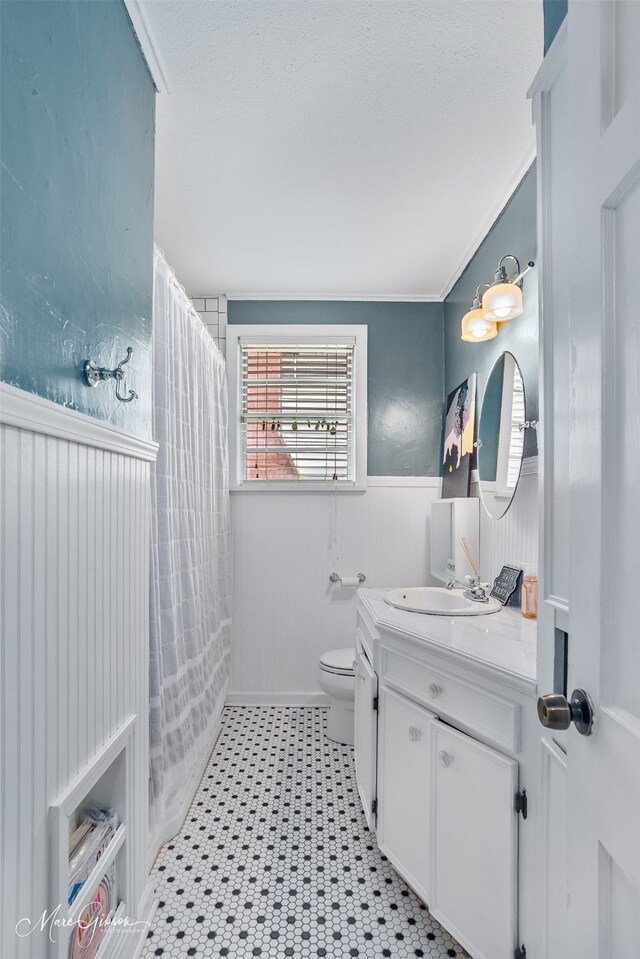 361 Carrollton Ave, Shreveport, LA 71105 - bathroom featuring vanity, a wainscoted wall, toilet, ornamental molding, and tile patterned floors