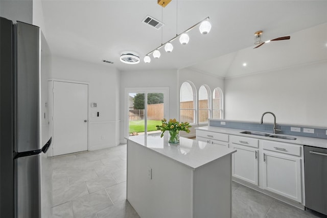 4309 Cutter Springs Ct, Plano, TX 75024 - kitchen with appliances with stainless steel finishes, a sink, white cabinets, ceiling fan, and a center island