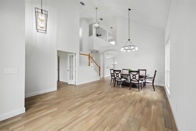 4309 Cutter Springs Ct, Plano, TX 75024 - dining room with stairway, high vaulted ceiling, arched walkways, light wood-style floors, and a chandelier