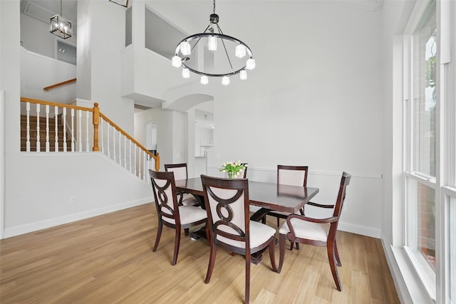 4309 Cutter Springs Ct, Plano, TX 75024 - dining room featuring a chandelier, wood finished floors, stairway, arched walkways, and baseboards