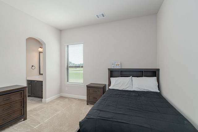 8220 Stonewall Dr, Waxahachie, TX 75167 - bedroom featuring arched walkways, light colored carpet, baseboards, and ensuite bath