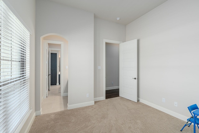 8220 Stonewall Dr, Waxahachie, TX 75167 - unfurnished bedroom with light carpet, arched walkways, and baseboards