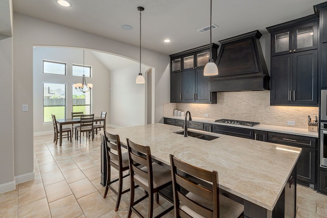 8220 Stonewall Dr, Waxahachie, TX 75167 - kitchen with custom exhaust hood, a sink, decorative backsplash, stainless steel appliances, and light stone counters