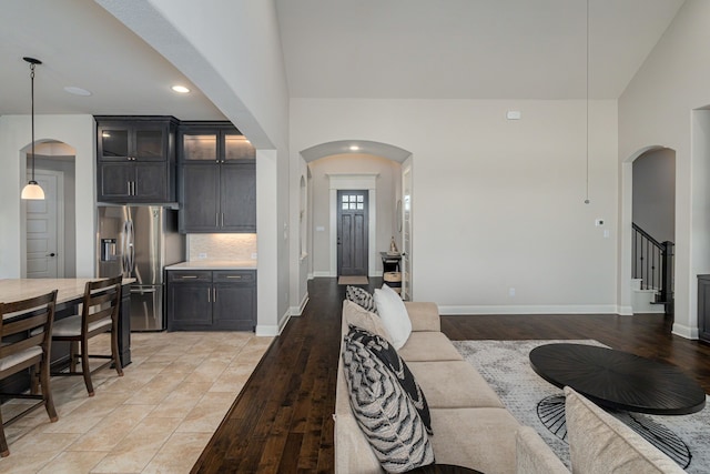 8220 Stonewall Dr, Waxahachie, TX 75167 - living area featuring arched walkways, light wood finished floors, baseboards, stairway, and recessed lighting