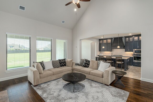 8220 Stonewall Dr, Waxahachie, TX 75167 - living area featuring arched walkways, a ceiling fan, high vaulted ceiling, dark wood finished floors, and baseboards