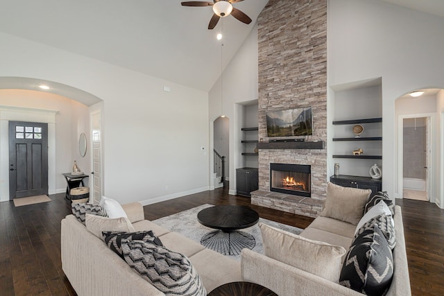 8220 Stonewall Dr, Waxahachie, TX 75167 - living room with high vaulted ceiling, ceiling fan, dark wood finished floors, arched walkways, and baseboards