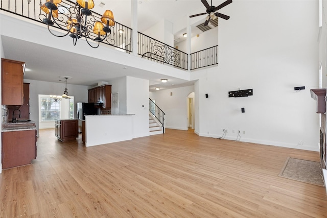 1084 Leisure Ln, Irving, TX 75063 - unfurnished living room with a chandelier, stairs, ceiling fan, light wood-type flooring, and a high ceiling