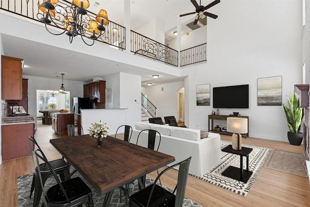 1084 Leisure Ln, Irving, TX 75063 - dining area with a chandelier, stairway, light wood-type flooring, ceiling fan, and a high ceiling