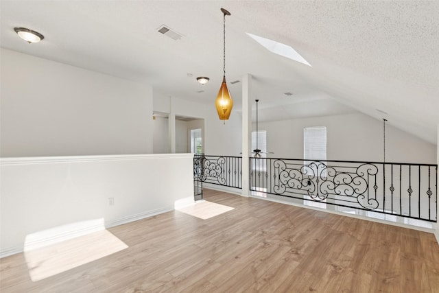 1084 Leisure Ln, Irving, TX 75063 - bonus room with wood finished floors, a skylight, vaulted ceiling, ceiling fan, and a textured ceiling