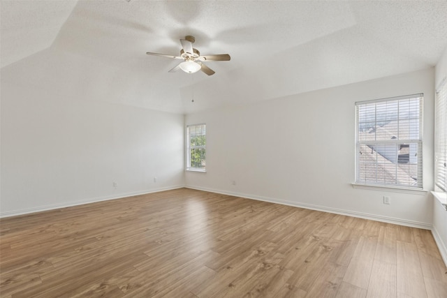 1084 Leisure Ln, Irving, TX 75063 - empty room with a ceiling fan, lofted ceiling, light wood-type flooring, and a textured ceiling
