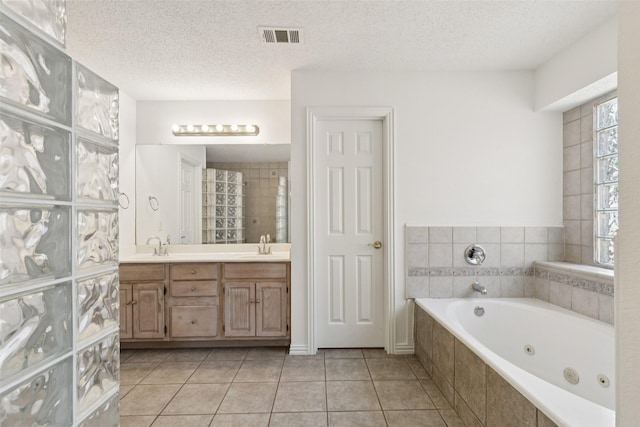 1084 Leisure Ln, Irving, TX 75063 - full bath with a jetted tub, double vanity, tile patterned floors, and a textured ceiling