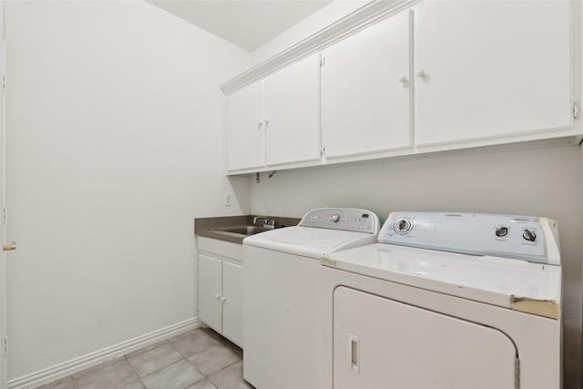 1084 Leisure Ln, Irving, TX 75063 - laundry area with washing machine and clothes dryer, cabinet space, and light tile patterned floors