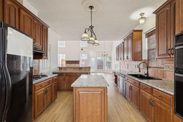 1084 Leisure Ln, Irving, TX 75063 - kitchen featuring stainless steel appliances, light wood-type flooring, a center island, plenty of natural light, and a textured ceiling