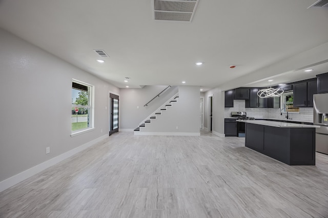703 E Center St E, Duncanville, TX 75116 - kitchen featuring a center island, stainless steel appliances, open floor plan, light countertops, and recessed lighting