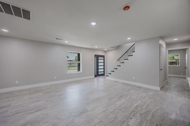 703 E Center St E, Duncanville, TX 75116 - unfurnished living room featuring recessed lighting, baseboards, stairs, and light wood-style floors