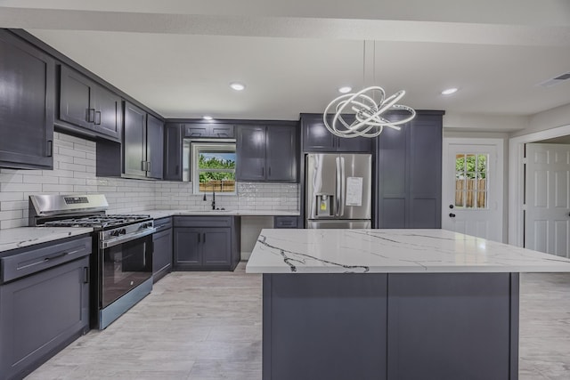 703 E Center St E, Duncanville, TX 75116 - kitchen featuring appliances with stainless steel finishes, light stone countertops, a chandelier, plenty of natural light, and recessed lighting
