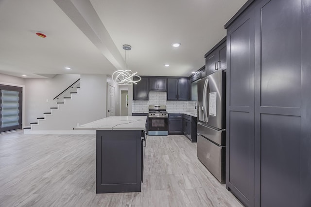 703 E Center St E, Duncanville, TX 75116 - kitchen with stainless steel appliances, light stone countertops, a kitchen island, light wood finished floors, and decorative backsplash