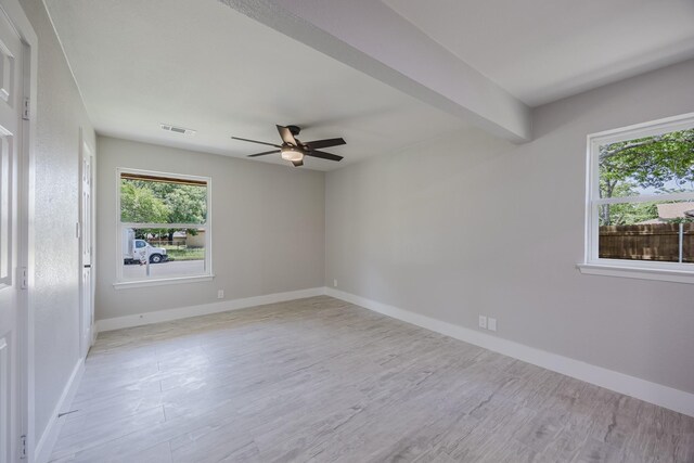 703 E Center St E, Duncanville, TX 75116 - empty room with ceiling fan, plenty of natural light, wood finished floors, and baseboards