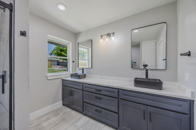 703 E Center St E, Duncanville, TX 75116 - full bathroom with double vanity, wood finished floors, baseboards, and recessed lighting